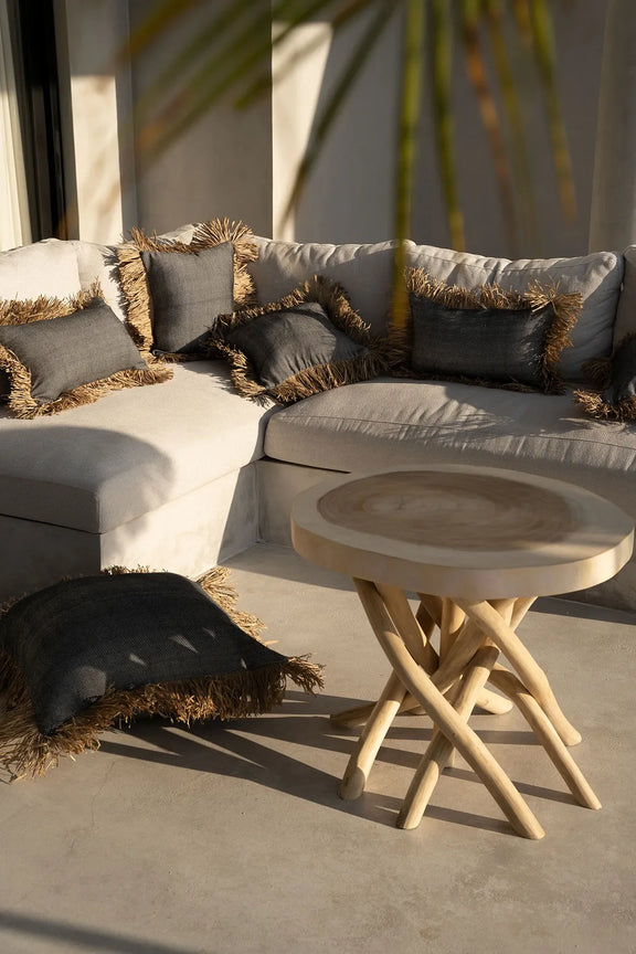 Housse de coussin coton et raphia noir naturel 30x50 sur canapé blanc avec coussins fringés