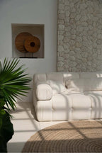 Canapé crème capitonné avec coussins doux et design minimaliste