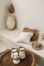 Porte-bougies en céramique blanche avec bordures en rotin tressé sur plateau bois