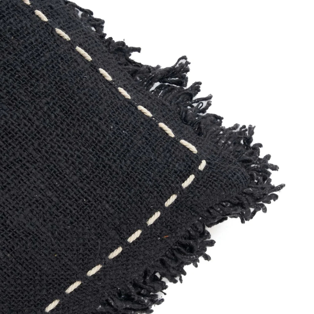 Tissu noir tissé avec des franges et des coutures blanches de la housse Kasbah