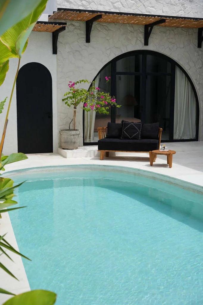 Coussin Kasbah Noir Blanc devant une piscine turquoise éclatante
