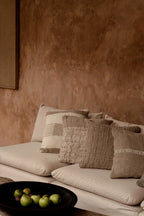 Canapé beige capitonné orné de coussins en lin texturé écru et beige naturel