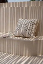 Oreiller blanc avec franges et design géométrique noir en coton pour décoration intérieure