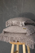 Coussins gris perle à franges empilés pour la décoration intérieure
