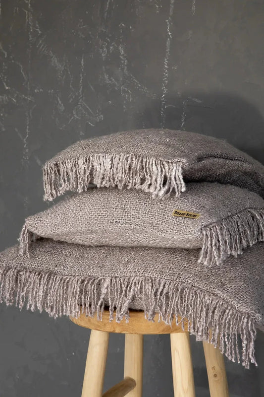 Coussins gris perle empilés avec franges de La housse de coussin Oh My Gee