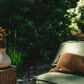 Vase rustique avec fleurs jaunes dans le cadre du coussin Oh My Gee Marron