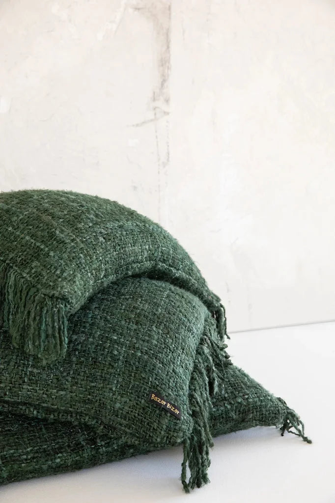 Couverture tissée à franges vertes affichée avec le coussin Oh My Gee Vert forêt