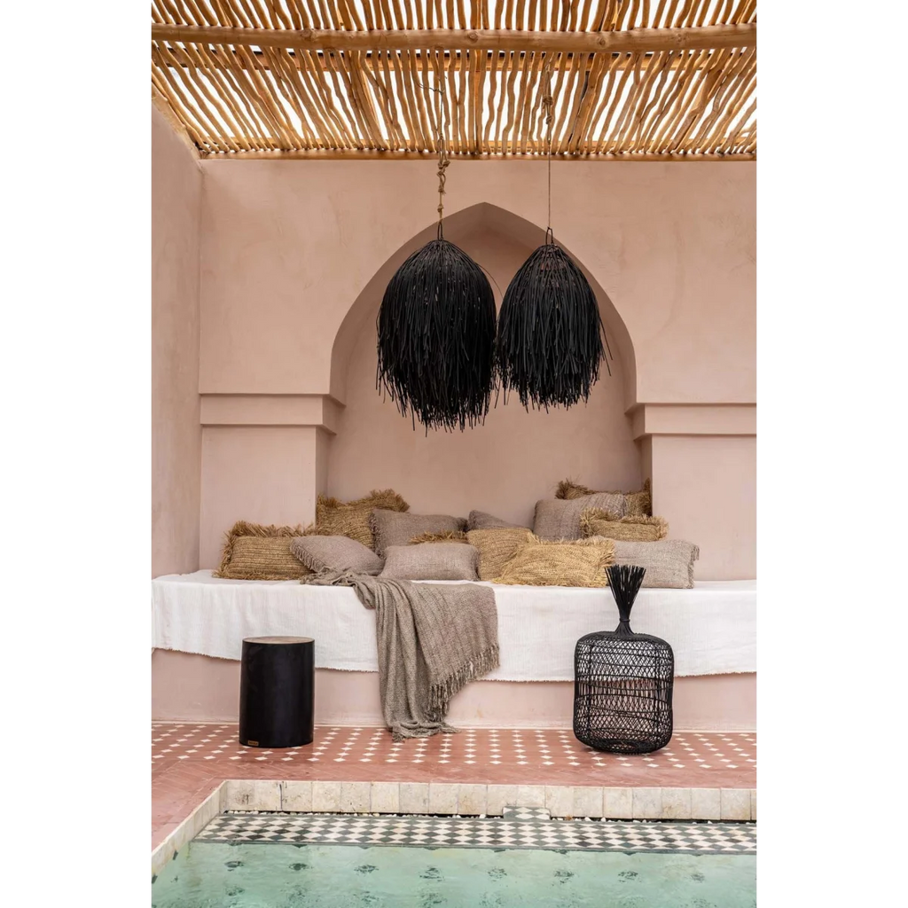 Housse de coussin rectangulaire en coton gris perle avec franges dans un espace lounge extérieur avec piscine