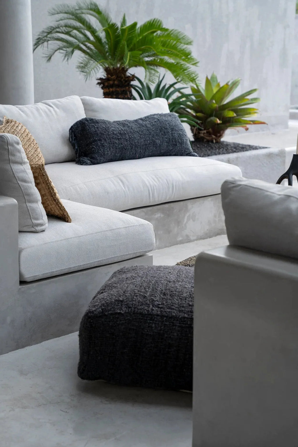 Canapé sectionnel blanc avec coussins gris, ottomane noire texturée, design moderne