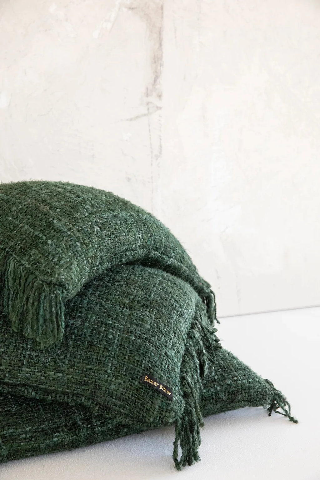 Coussin rectangulaire en coton vert foncé avec franges et texture douce