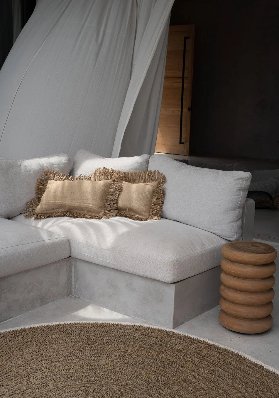 Housse de coussin rectangulaire en jute naturel avec franges décoratives dans un salon neutre