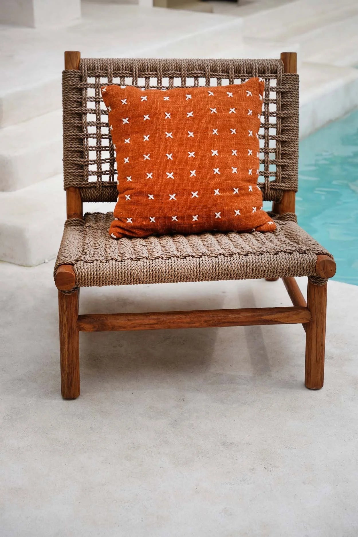 Chaise en bois avec coussin orange brodé en coton motif croix blanches 50x50 cm