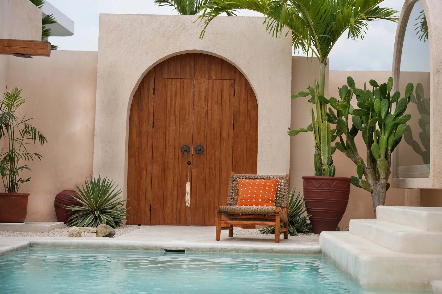 Porte en bois arquée avec poignées en métal décoratives, idéale pour un décor rustique
