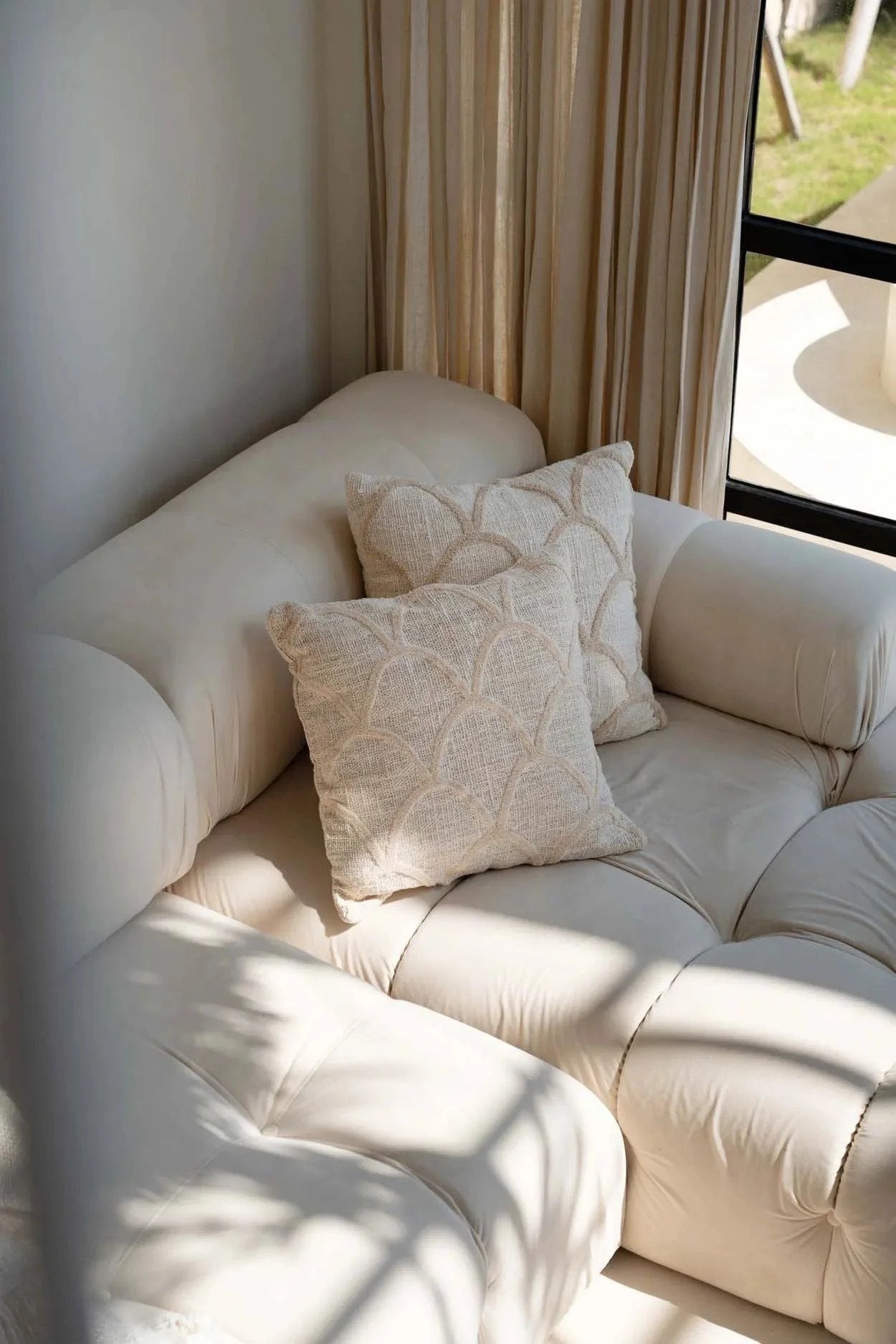 Canapé sectionnel couleur crème avec coussins décoratifs en tissu naturel coquilles