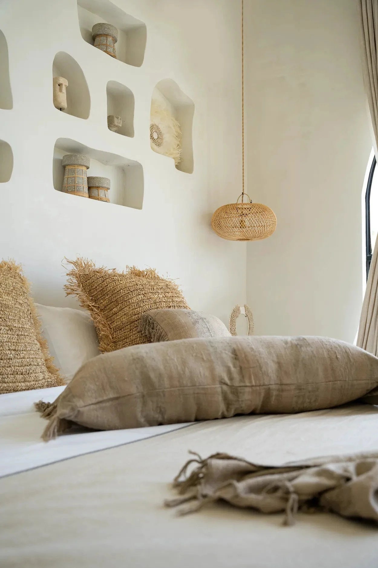 Housse de coussin velours béton 100x35 cm dans une chambre neutre avec oreillers texturés