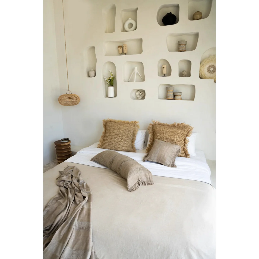 Housse de coussin en velours béton 40x40 cm sur un lit avec duvet et coussins