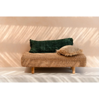 Banquette en rotin tissé avec deux coussins décoratifs verts forêt en coton