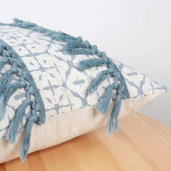 Zoom sur les motifs géométriques et franges de la housse de coussin bleu géométrique
