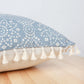 Zoom sur les détails des motifs géométriques et franges de la housse de coussin bleu