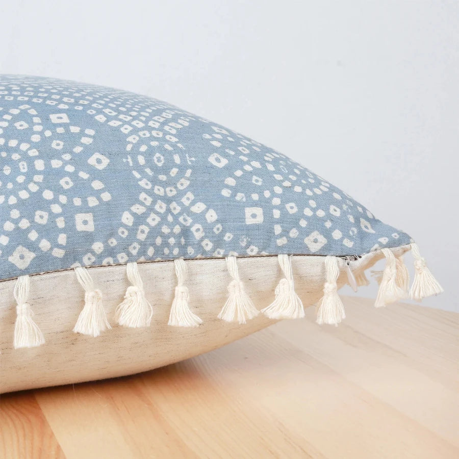 Zoom sur les détails des motifs géométriques et franges de la housse de coussin bleu