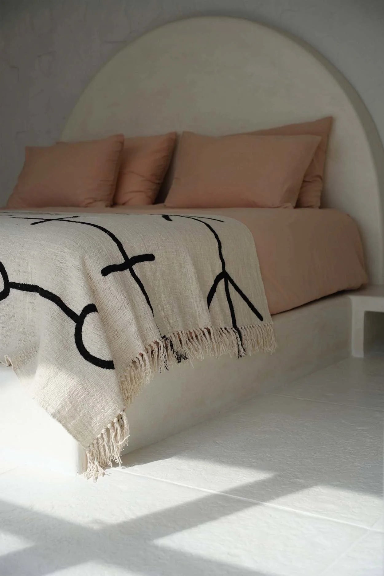 Lits minimaliste avec jeté de lit en coton noir naturel motif œil protecteur et franges