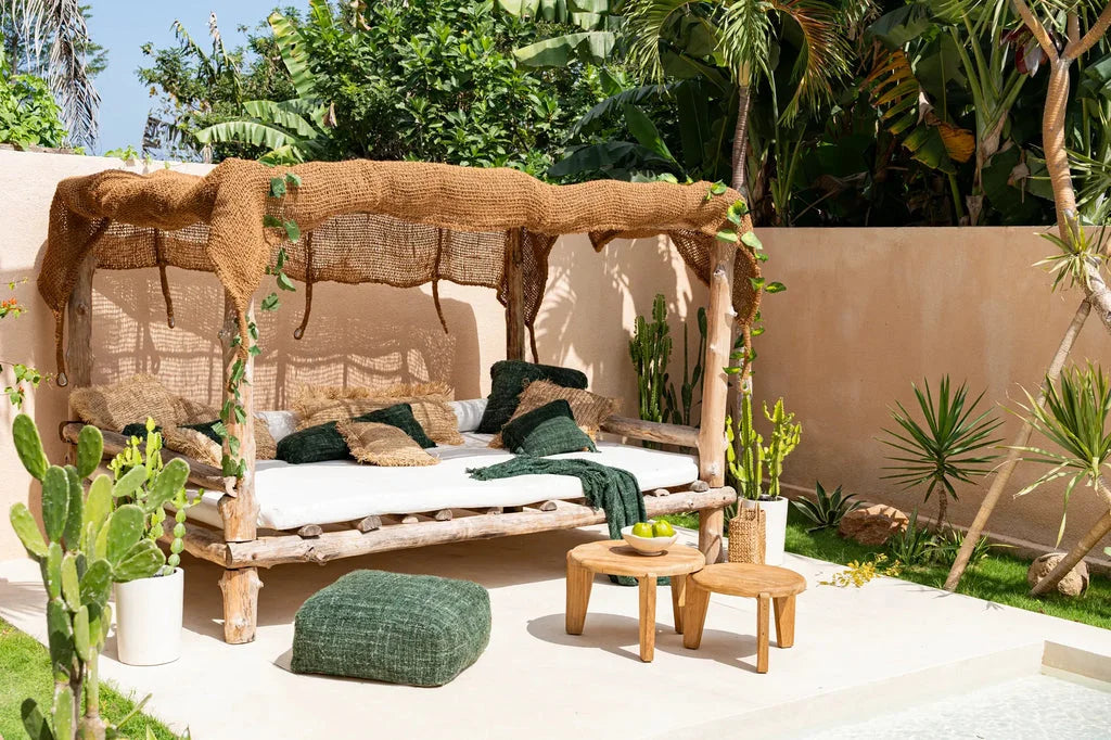 L’abat-jour triangulaire Coco Shade Naturel 350x350 sur un lit de jour extérieur rustique avec canopy