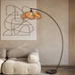  Lampadaire moderne avec base en métal et abat-jour en rotin, posé près d'un canapé design.
