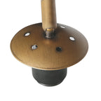 Disque en métal bronze avec trous, attaché à un cylindre, sur une base noire