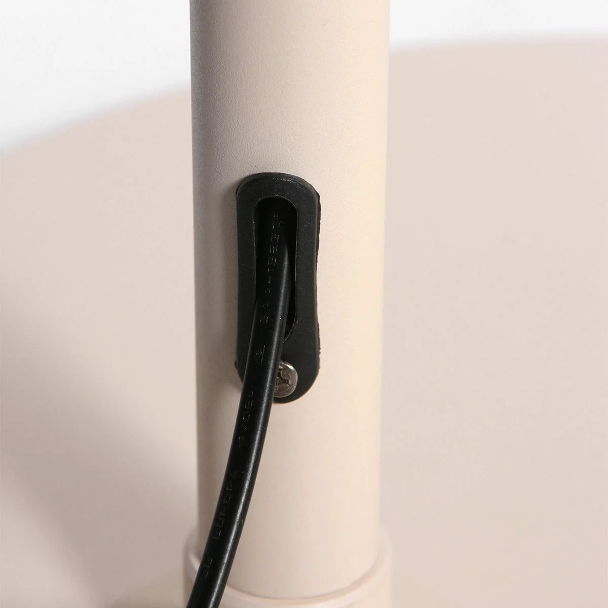 Câble noir fixé à un poteau blanc pour le lampadaire arc en rotin tressé crème avec abat-jour rond H240 cm