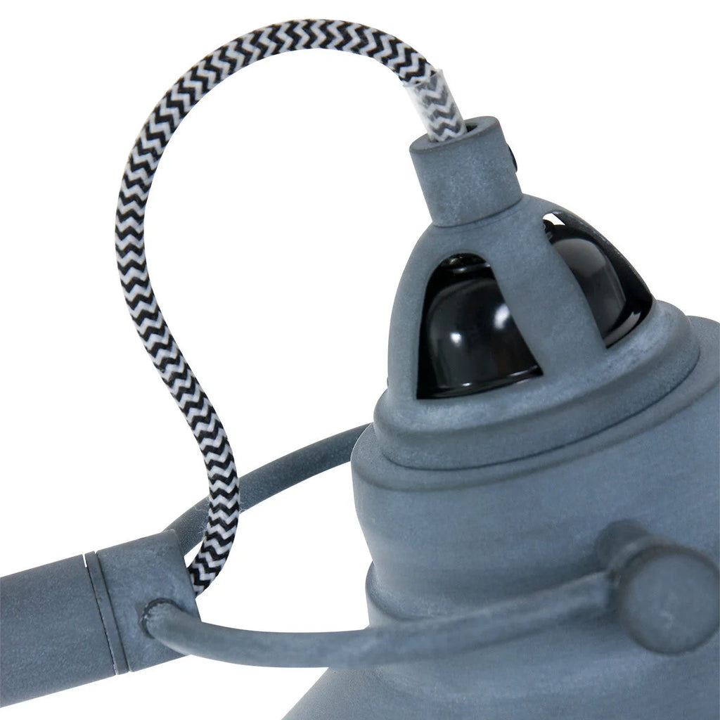 Lampadaire en métal gris avec bras articulé, abat-jour conique et cordon patterné