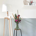 Bouquet de fleurs colorées dans un vase en verre clair avec lampadaire tripode bois