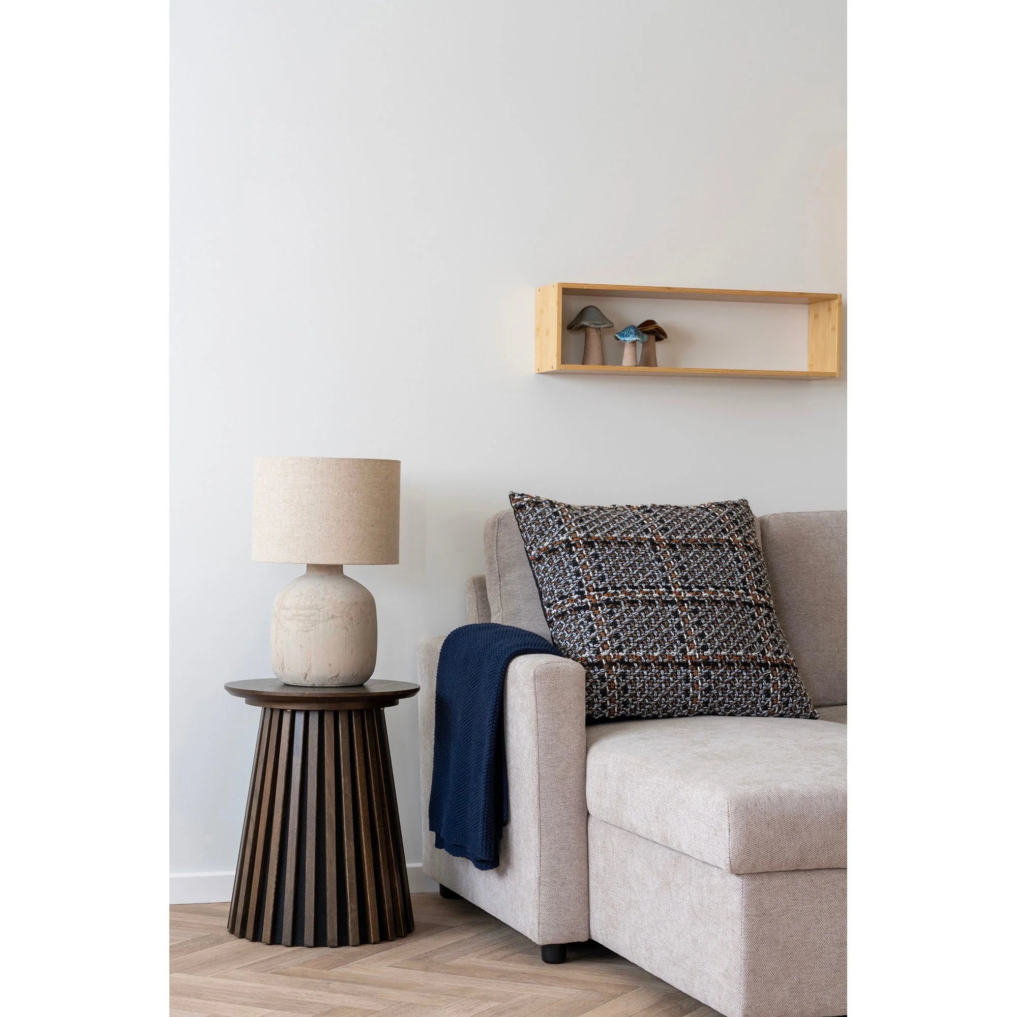 Lampe à poser en céramique texturée beige avec abat-jour en lin écru sur table en bois