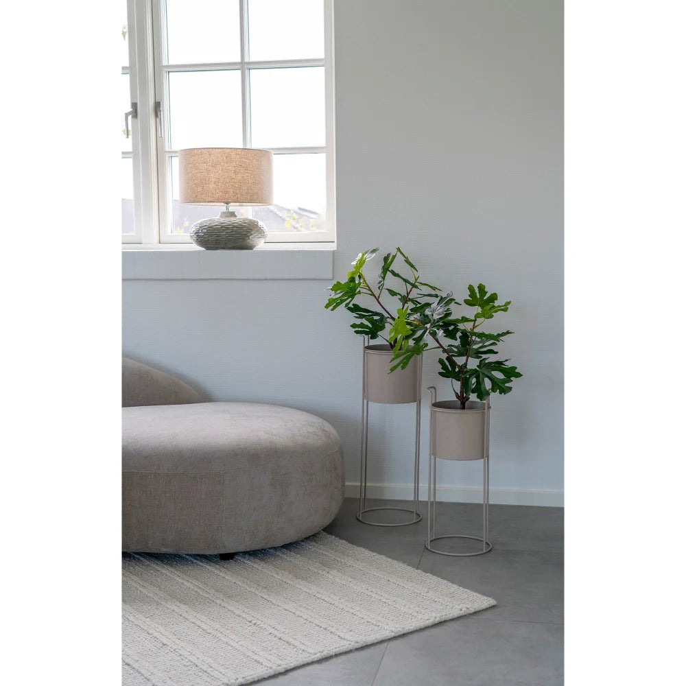 Intérieur avec plantes et mobilier mettant en valeur la lampe en céramique verte et abat-jour beige
