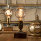 lampe bois vintage allumée avec ampoule ronde filament sur une table