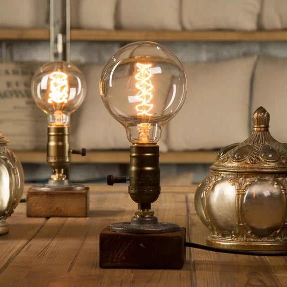 lampe bois vintage allumée avec ampoule ronde filament sur une table
