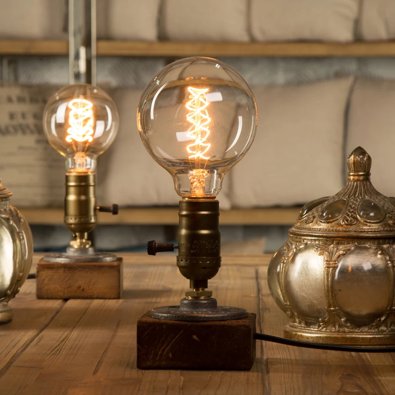 lampe bois vintage allumée avec ampoule ronde filament sur une table