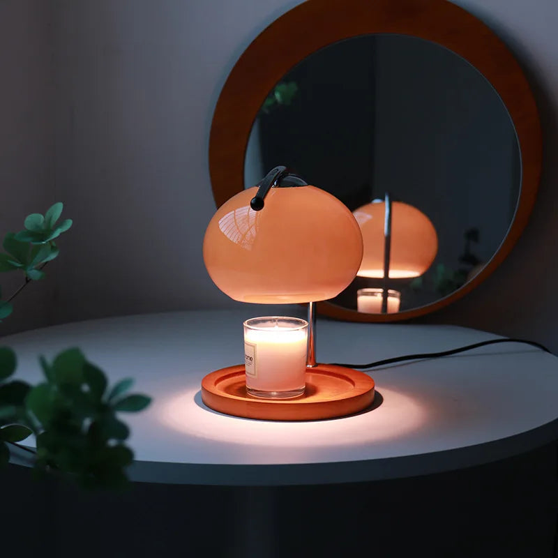 Lampe chauffe-bougie en verre orange  allumée