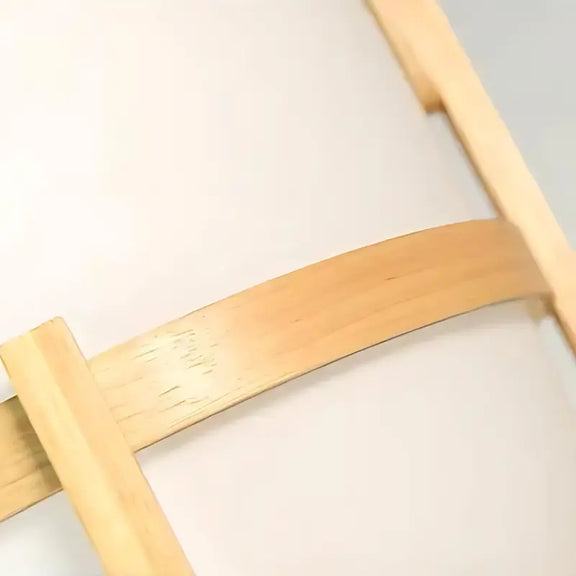 Détail du support en bois clair d'une lampe à pied.