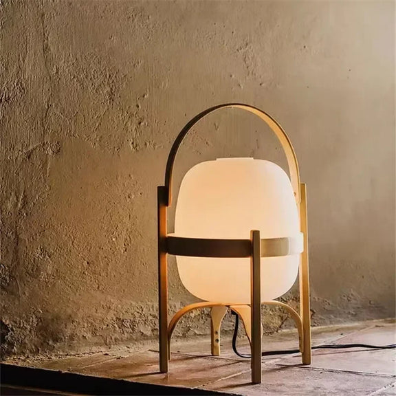 Lampe à pied en bois de taille moyenne avec abat-jour blanc, posée sur un sol
