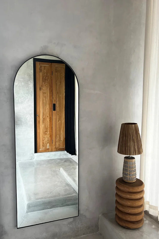 Miroir arqué à cadre noir avec La lampe de table Naxos en béton naturel