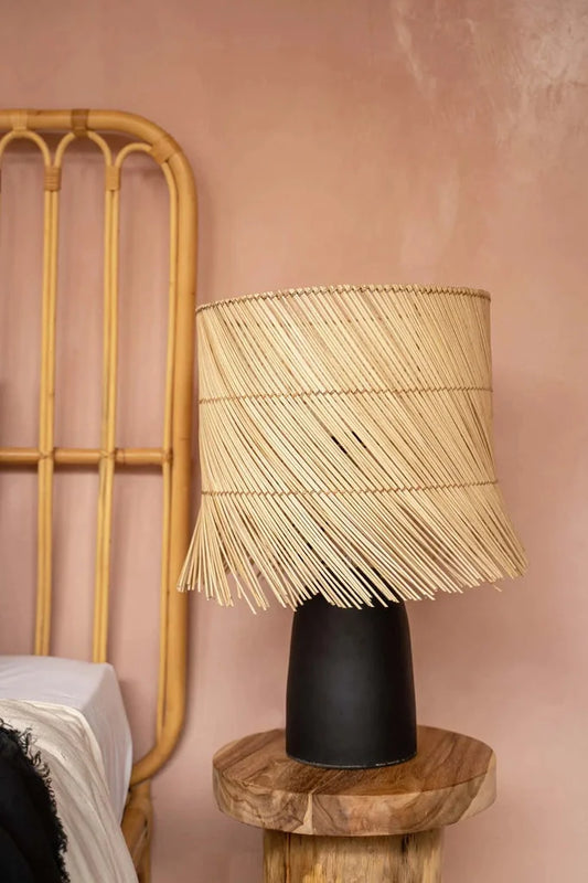 Abat-jour en rotin naturel sur une base noire, lampe de table élégante et artisanale