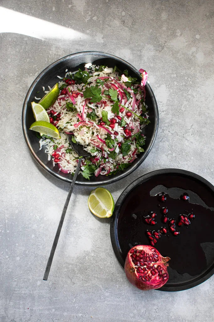 Salade de riz avec grenade et citron vert dans L’assiette creuse brûlée Noire M