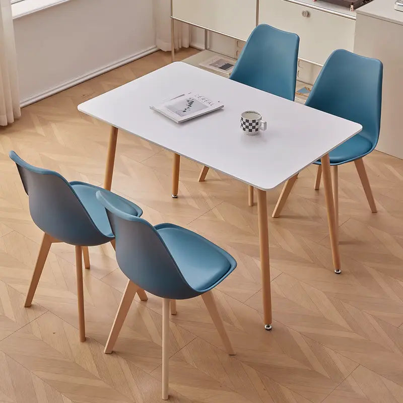 Lot de 4 chaises scandinaves bleues autour d’une table blanche dans une cuisine