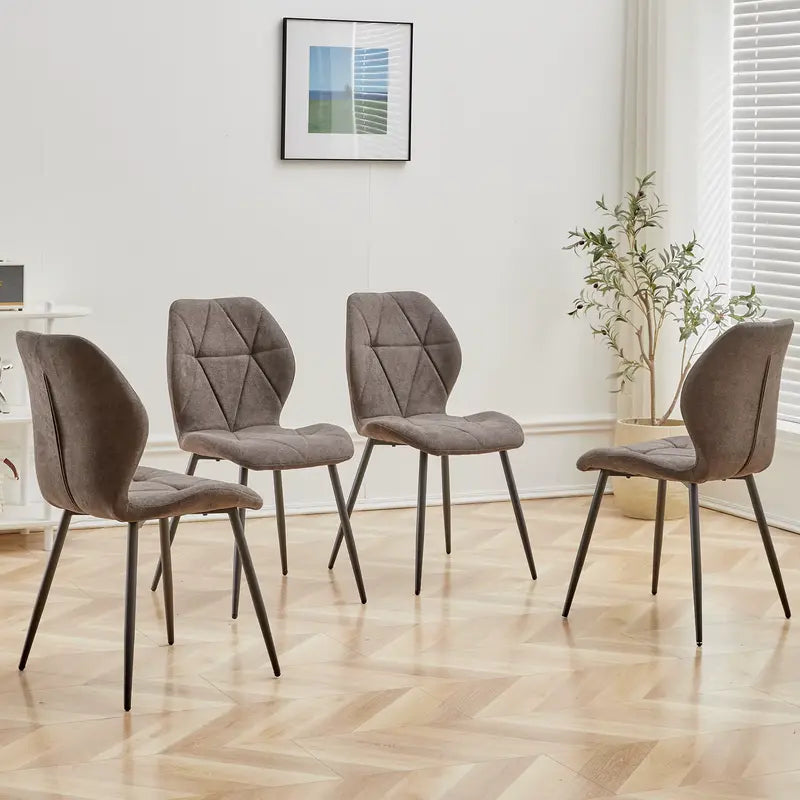 Ensemble de 4 chaises en tissu gris, installées autour d'une table dans une salle à manger.