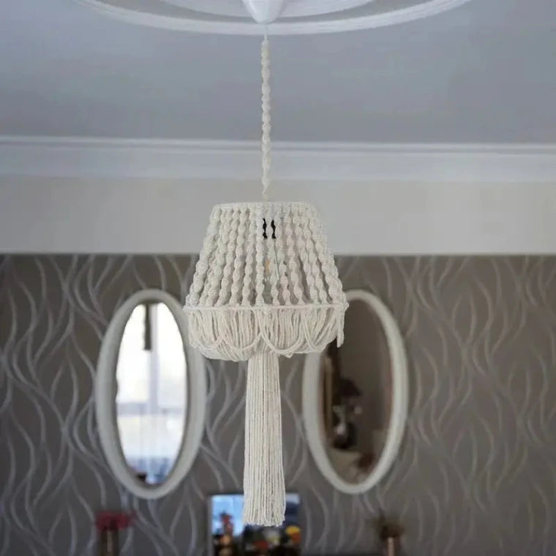 Lustre en macramé suspendu installé dans une pièce avec des miroirs muraux.