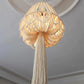 Lustre en macramé suspendu avec la lumière allumée, créant une ambiance chaleureuse.