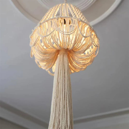 Lustre en macramé suspendu avec la lumière allumée, créant une ambiance chaleureuse.