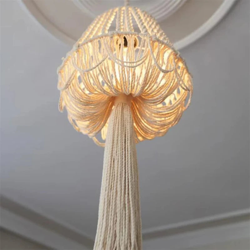 Lustre en macramé suspendu avec la lumière allumée, créant une ambiance chaleureuse.