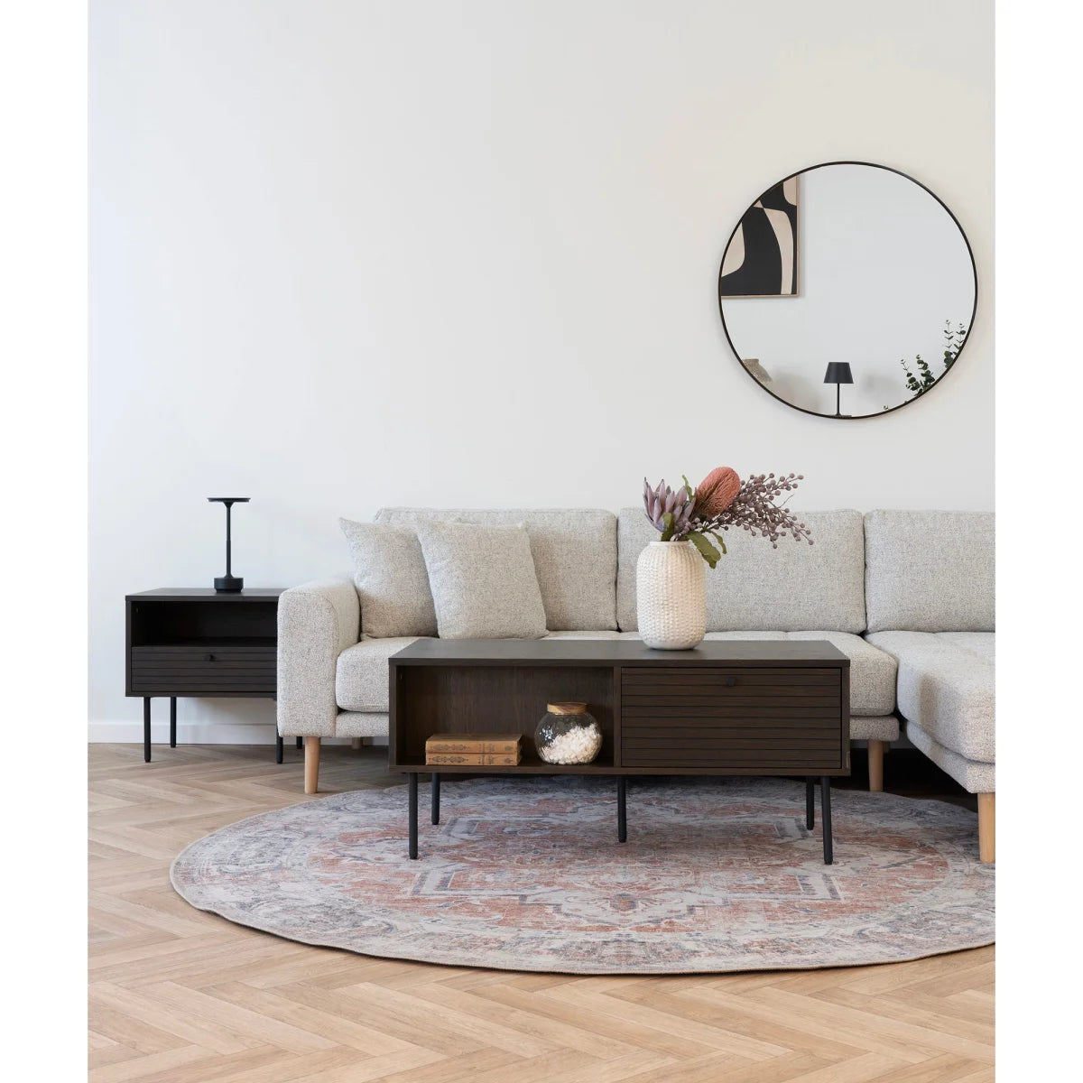 Vase céramique texturé blanc avec fleurs séchées sur meuble TV bas en bois fumé et métal noir 100x50 cm