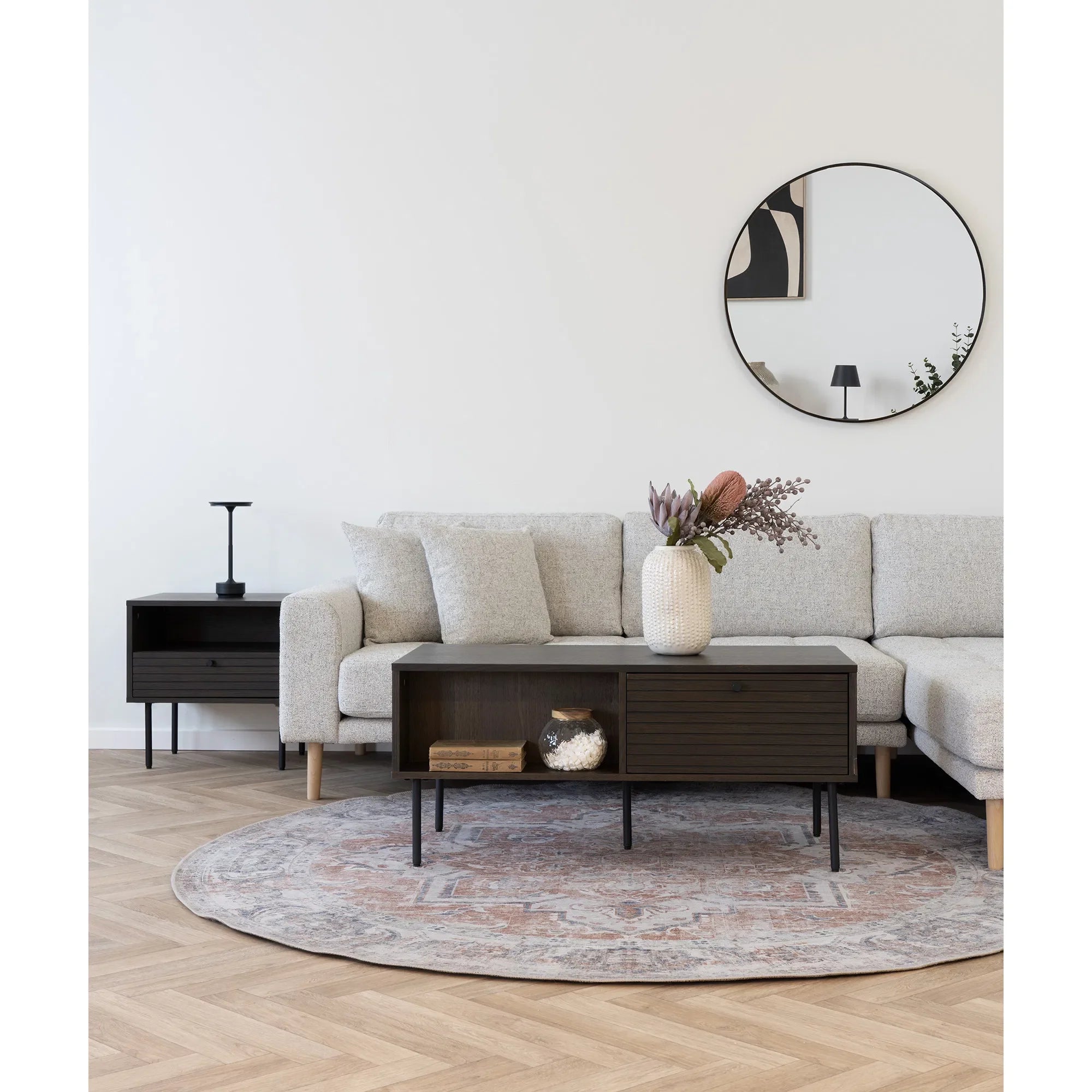 Salon moderne avec canapé gris clair, table basse en bois fumé et métal noir